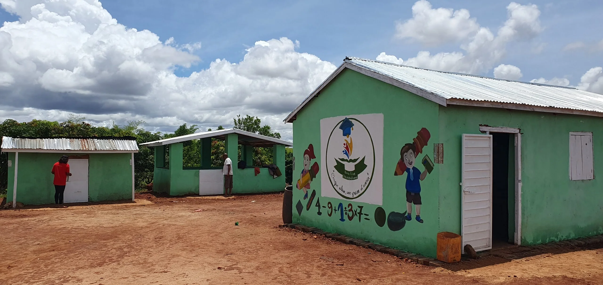 La cour et les bâtiments verts de l’école.
